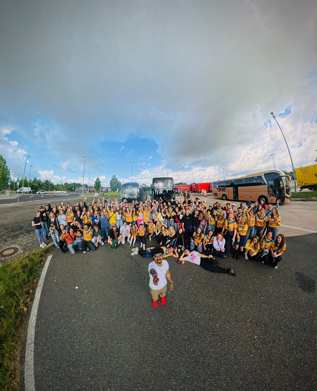 Wide group photo of the whole Medimeister crowd with the coaches parked behind