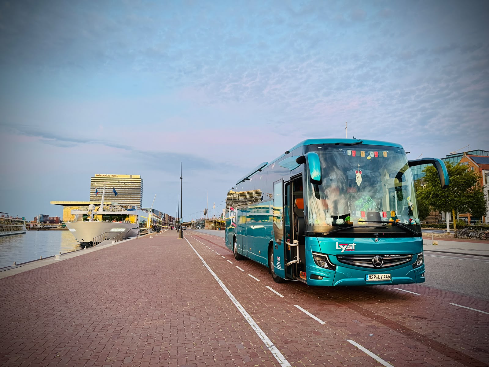 Our teal Lyst coach parked along the Amsterdam harbour at dawn